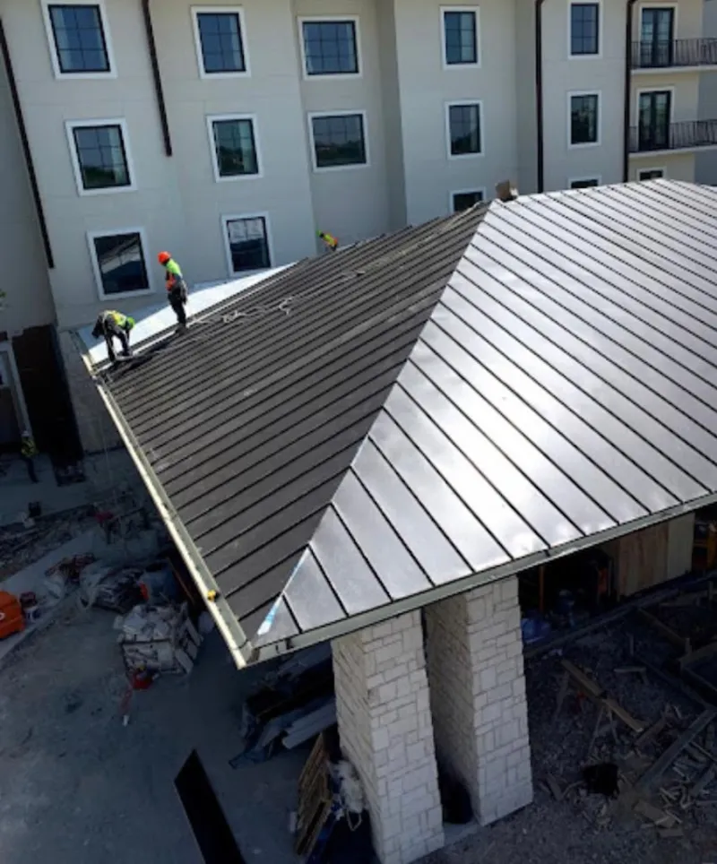 Crew installing standing seam metal roof panels on a commercial project in Glendale